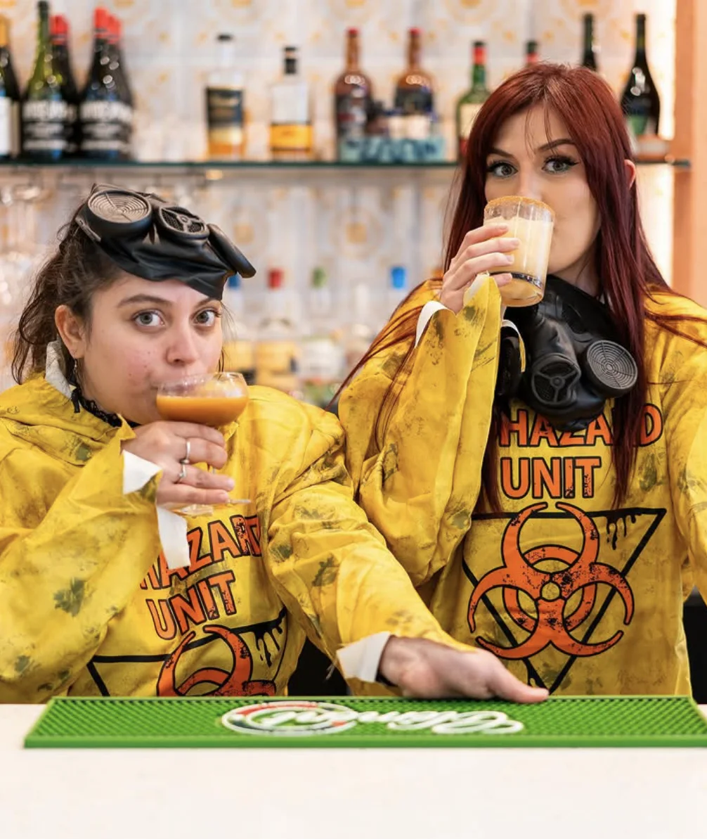 Girl Bar founders Haley Herebia and Zoe Sanchez sharing cocktails behind the bar