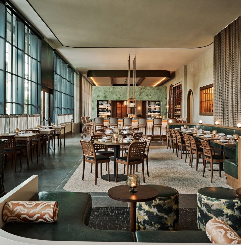Sargent's dining room: tall steel windows, a green Venetian plaster bar, emerald banquettes and globe lights